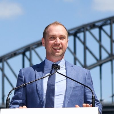 John Lamerton speaking in front of the Sydney Harbour Bridge